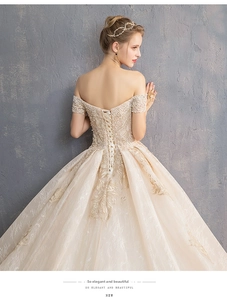 Detail of elegant off-the-shoulder bridal gown with lace embroidery and corset back