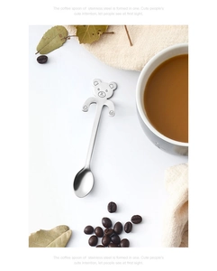 Macro shot of 304 stainless steel bear coffee spoon beside a coffee cup on white table