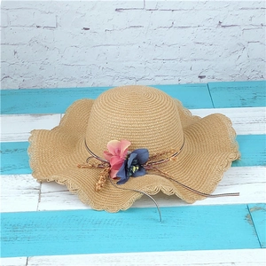 Women's summer straw sun hat with large wavy brim and elegant floral bow decoration