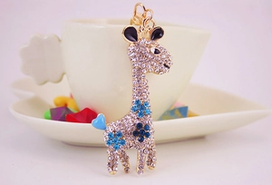 Close-up of golden giraffe keychain with blue and clear crystal rhinestones