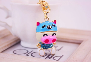 Détail du porte-clés cochon avec casque en émail bleu et strass bleus étincelants