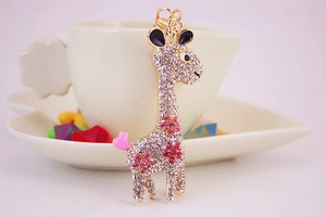Detail view of golden giraffe keychain with pink rhinestones and a heart charm