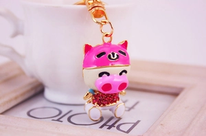 Gros plan du porte-clés cochon en métal avec casque rose et strass brillants