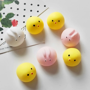 Flat lay of colorful squishy pig and chick stress relief toys on a decorative card