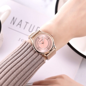 Elegant rose gold mesh strap watch with pink dial shown with soft cozy knitwear