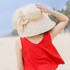Foldable wide brim straw sun hat for women with beige bow and colorful spots