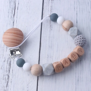 Detail of baby pacifier clip with wood beads, silicone balls and BABY letter engraving