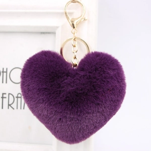 Detailed close-up of a soft purple heart-shaped plush keychain with a gold metal clasp