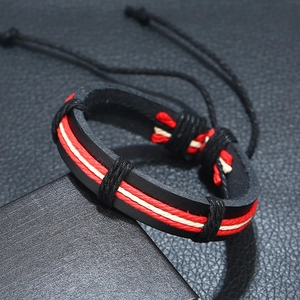 Detailed close-up of woven leather bracelet featuring red and cream braided accents