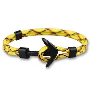 Détail du bracelet en nylon jaune avec boucle en métal en forme d'ancre noir mat