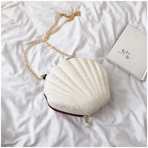 Top view of white glitter shell crossbody bag with gold chain and red interior lining