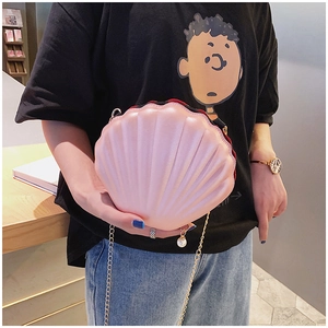 Pink shell shaped crossbody bag with gold chain strap and pearl detail on model