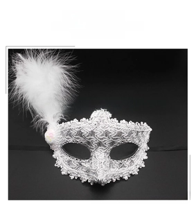 Close-up of white feather details and silver lace texture on the Venetian party mask