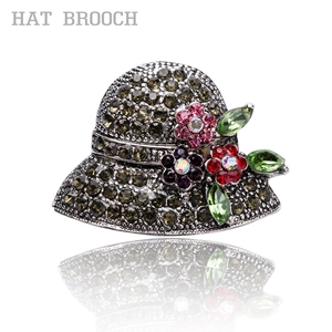 Retro vintage hat brooch with multi-colored crystals and flower details on white background