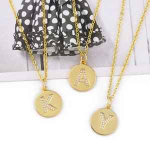 Detailed close-up of golden round pendant necklaces with K, A, and Y zircon initials