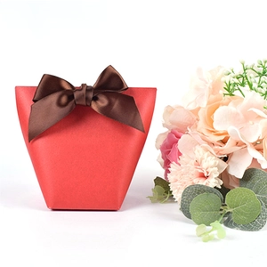 Elegant red pearlescent gift box with brown satin ribbon and decorative flowers