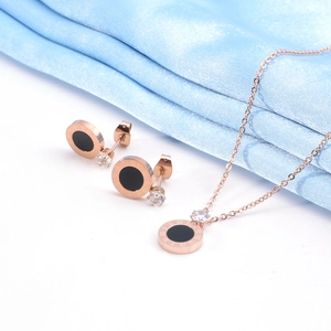 Détail d'une parure en or rose avec disques à chiffres romains noirs sur soie