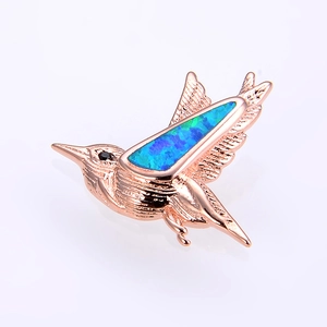 Makroansicht Kolibri-Anhänger in Roségold mit blau-grünem Opal und schwarzem Schmuckstein-Auge
