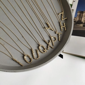 Detailed view of 925 silver golden alphabet necklaces with unique bamboo texture detail