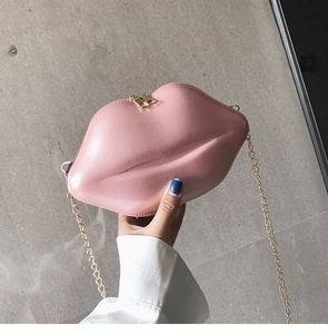 Detailed view of pink glossy patent leather lip-shaped bag with gold metal chain