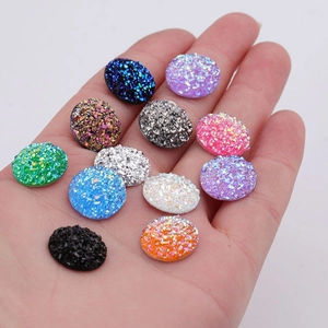 Mix of 14mm round colorful resin druzy stones for DIY jewelry making displayed on a palm