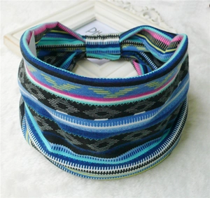 Detail of wide bohemian elastic headband with geometric patterns on plush white surface