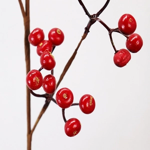 Macro di bacche rosse artificiali con glitter dorati su rami decorativi marroni