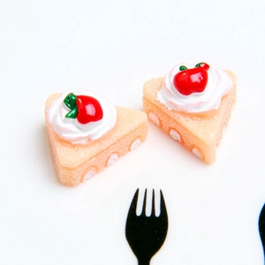 Top view of two resin cake slices with white cream and strawberry for DIY crafts
