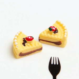 Macro view of miniature resin yellow strawberry cake slices with small fork props