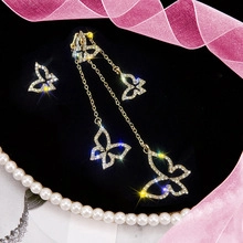 Detailed macro view of golden butterfly jewelry set with rhinestones and tassel design