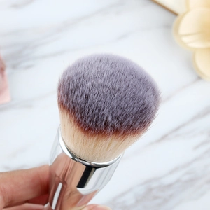 Macro detail of bicolored synthetic bristles on a professional powder brush with silver ferrule