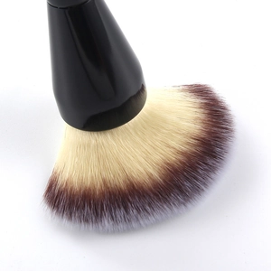 Macro detail of bicolored loose powder brush with soft fibers and sleek black handle