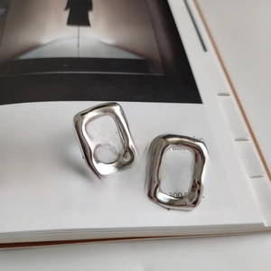 Irregular silver 925 sterling earrings in a rectangle design on a minimal art magazine