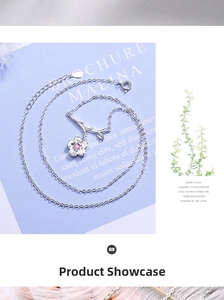 Close-up of silver cherry blossom necklace with pink gemstone and branch detail