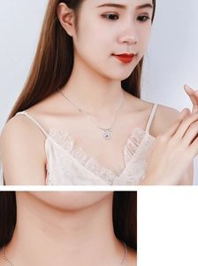 Close-up of a silver flower necklace with purple stones on a model's neck
