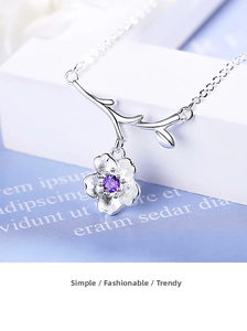 Detailed view of silver flower pendant necklace with frosted petals and purple zircon gem