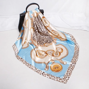 Detail of luxury silk scarf with gold chain and leopard print styled with a handbag