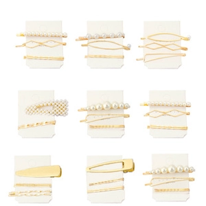 Detail view of pearl and gold hair clip sets arranged on white display cards