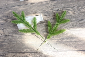 Detailed macro view of artificial plastic pine needles branches on a wooden surface