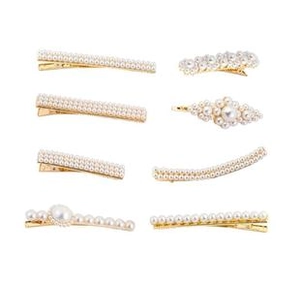 Set of 8 gold pearl hair clips with flower and heart shapes on a plain background