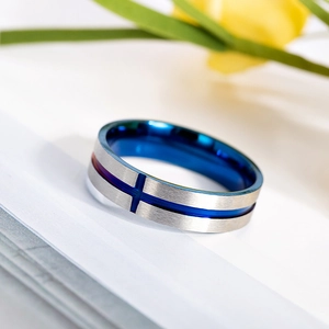 Close-up of vintage stainless steel ring featuring blue groove and cross design accents