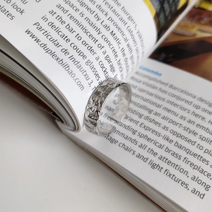 Macro shot of S925 sterling silver ring with rustic rock texture on vintage book page