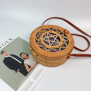 Detail of round rattan bag with star cutout design and floral fabric lining inside