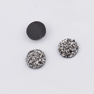 Detailed view of 10mm flatback resin cabochons showing textured silver glitter and smooth back