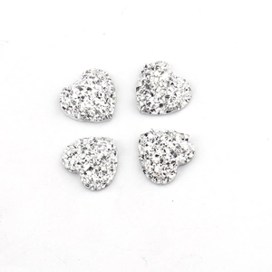 Macro detail van 12mm zilveren hartvormige resin bedeltjes met getextureerde glitter