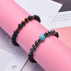 Lava rock and tiger eye beaded stretch bracelets set with black matte stones on pink stand