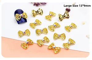Detail of 13x9mm golden bow nail charms with rhinestones on a blue nail tip
