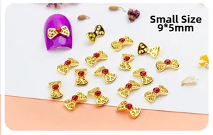 Detailed macro view of 9x5mm gold bow nail charm with red rhinestone and display