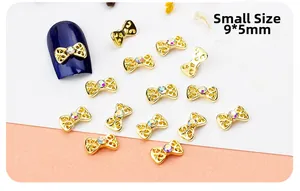 Macro shot of small gold alloy bow nail art charm with a crystal rhinestone center