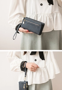 Detail of dark blue vintage long wallet with gold zippers and detachable wristlet strap